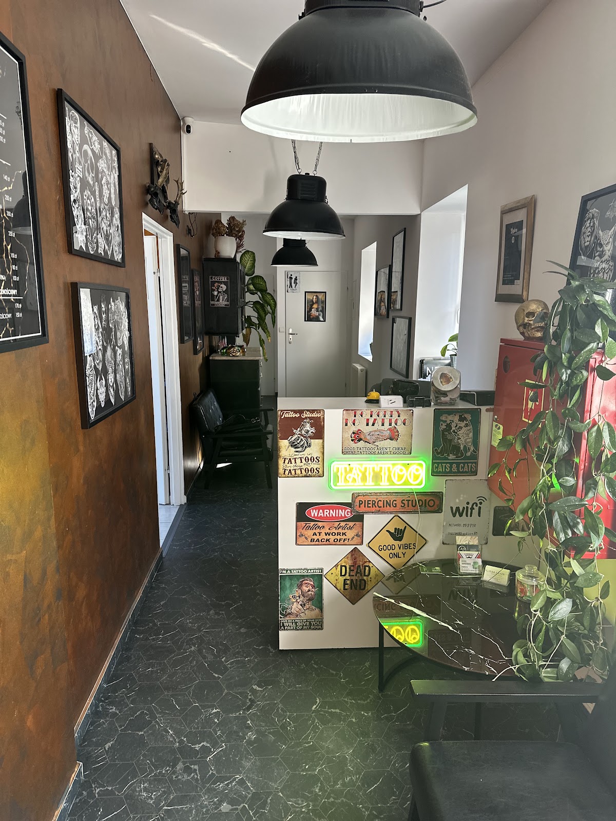 Wnętrze Edison Tattoo - recepcja, plakaty, neon tattoo